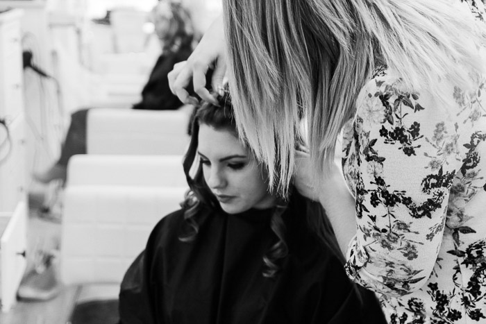 A black and white shot of photography models getting hair and make up done